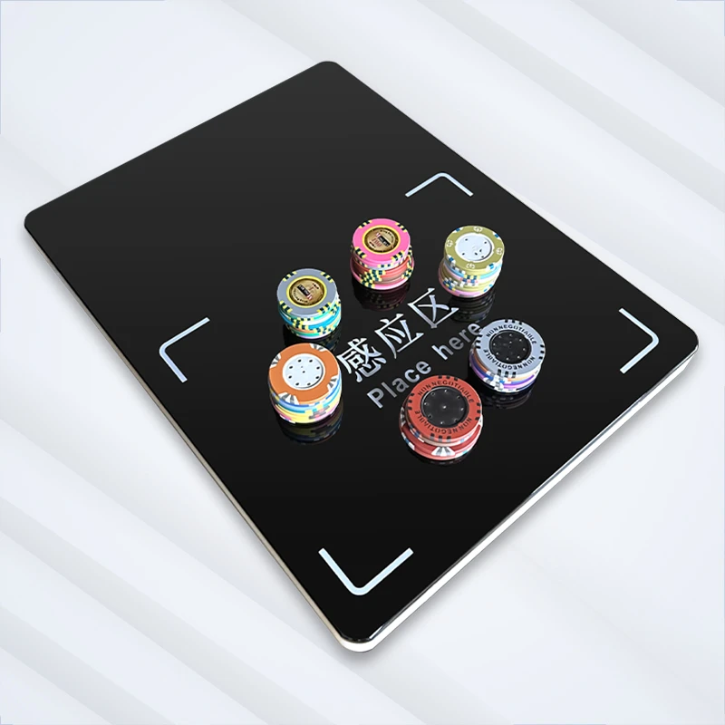 Casino RFID chip reader angled view with multiple denomination chip stacks on the sensing zone