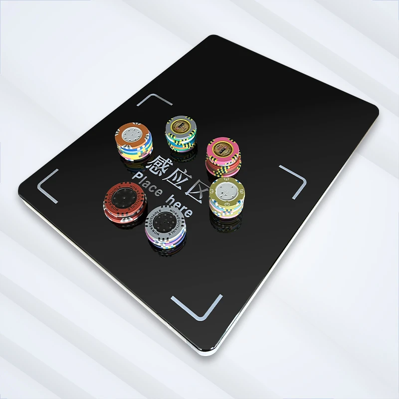 RFID cage chip reader with six stacks of colorful casino poker chips on the sensor surface